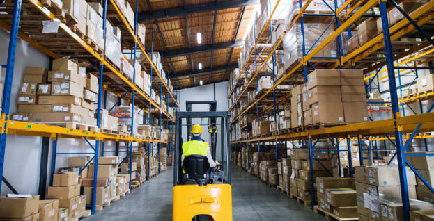 forklift going through aisle of warehouse